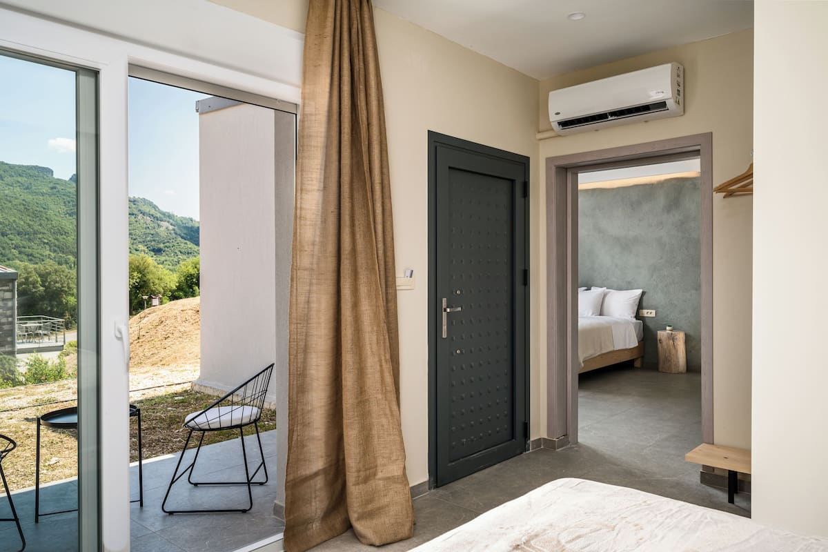 Une chambre à coucher avec un lit, une table de chevet, une chaise et une vue sur l’extérieur.