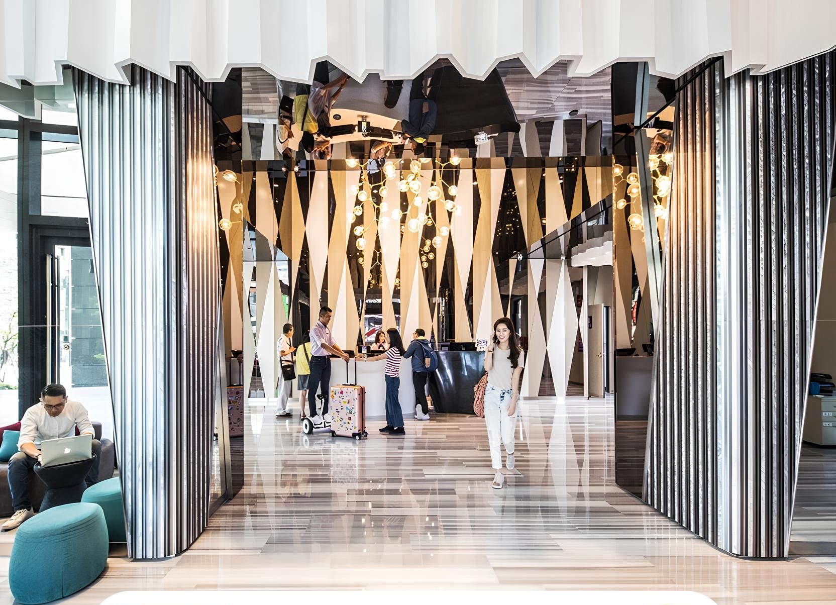 A modern hotel registration area with a contemporary design, featuring geometric patterns and a central reception desk.