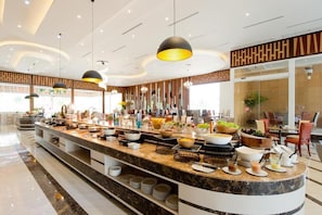 Un hall d’hôtel moderne avec un comptoir d’accueil en marbre, plusieurs espaces de détente et une grande fenêtre laissant entrer la lumière naturelle.