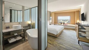 A modern hotel room with a large bed, a separate bathroom with a bathtub, a large mirror, and a city view. - Yong Le Lukang, a Tribute Portfolio Hotel (Lukang)