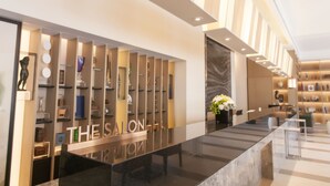A modern reception area with a sleek black counter, a sign reading "THE SALON," and a well-lit interior with shelves displaying various items. - Yong Le Lukang, a Tribute Portfolio Hotel (Lukang)