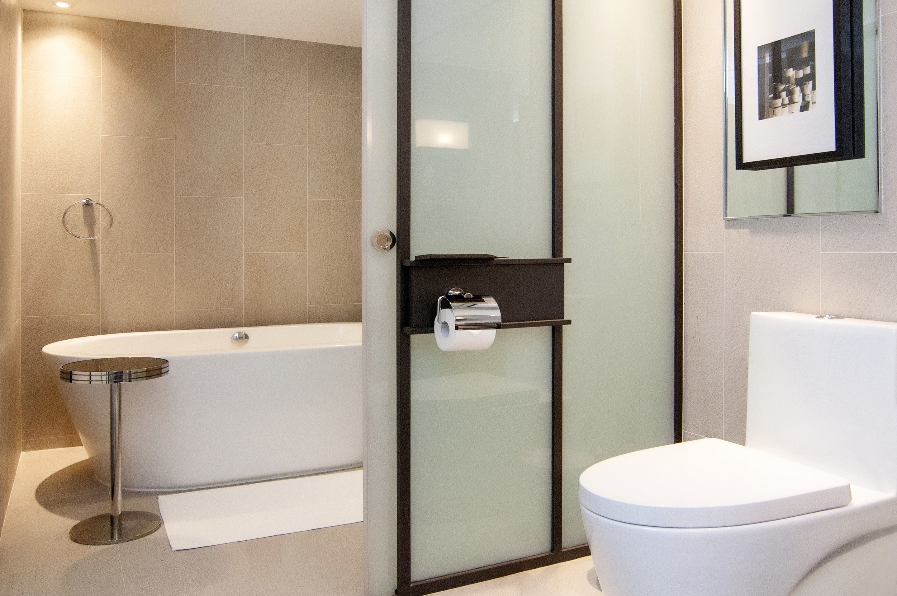 Un baño moderno con bañera, inodoro y cabina de ducha de vidrio.