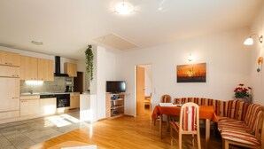 A modern apartment with a kitchen, dining area, and living room. - Appartmenthaus Freiler (Morbisch am See)