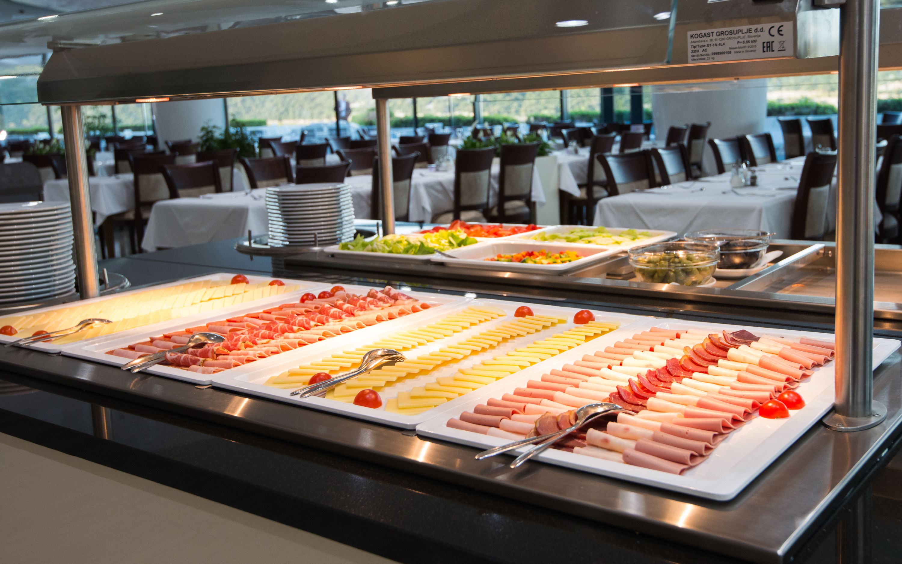 Un bufé con diversas opciones de comida, incluyendo carnes, quesos y ensaladas.