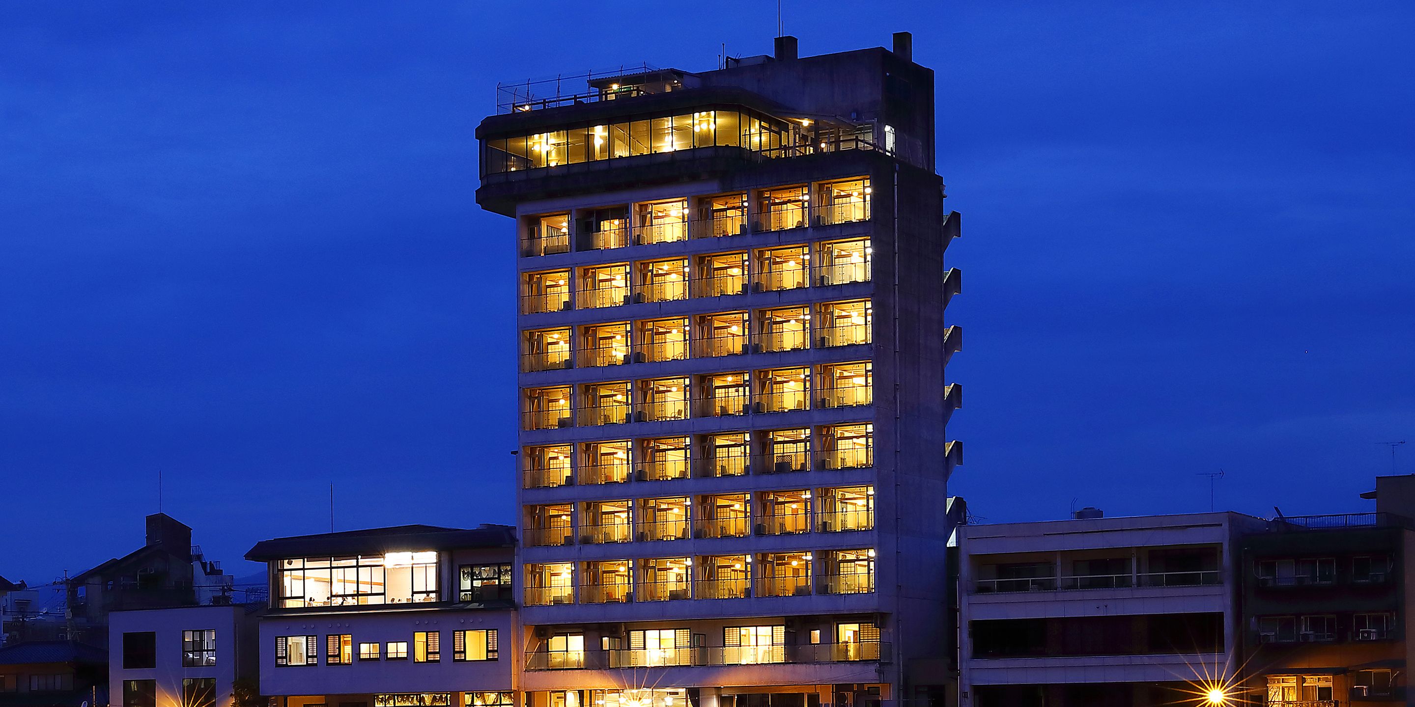 A multi-story building with illuminated windows, likely a hotel or apartment complex.