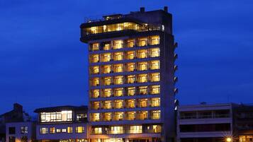 A multi-story building with illuminated windows, likely a hotel or apartment complex.