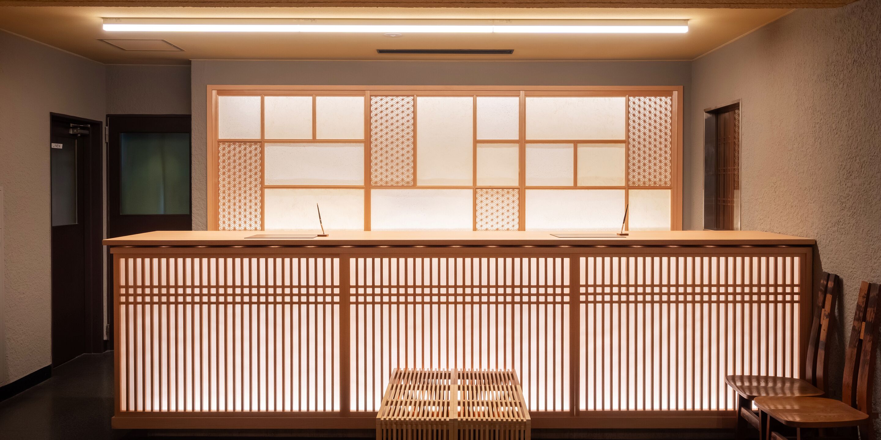 A reception desk with a traditional Japanese design, featuring sliding doors and a wooden counter.