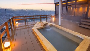 A wooden deck with a hot tub, a wooden bench, and a view of the cityscape. - Shokyoto No Yu Mikuma Hotel (Hita)