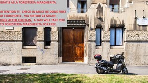 A building with a large wooden door and a sign above it. - Foresteria Margherita Milano (Milan)