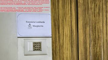 A sign with "Foresteria Lombarda Margherita" and a doorbell.