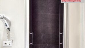 Un baño con un lavabo blanco, un secador de pelo y un espejo.