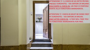 A hallway with marble steps leading to a door. - Foresteria Margherita Milano (Milan)