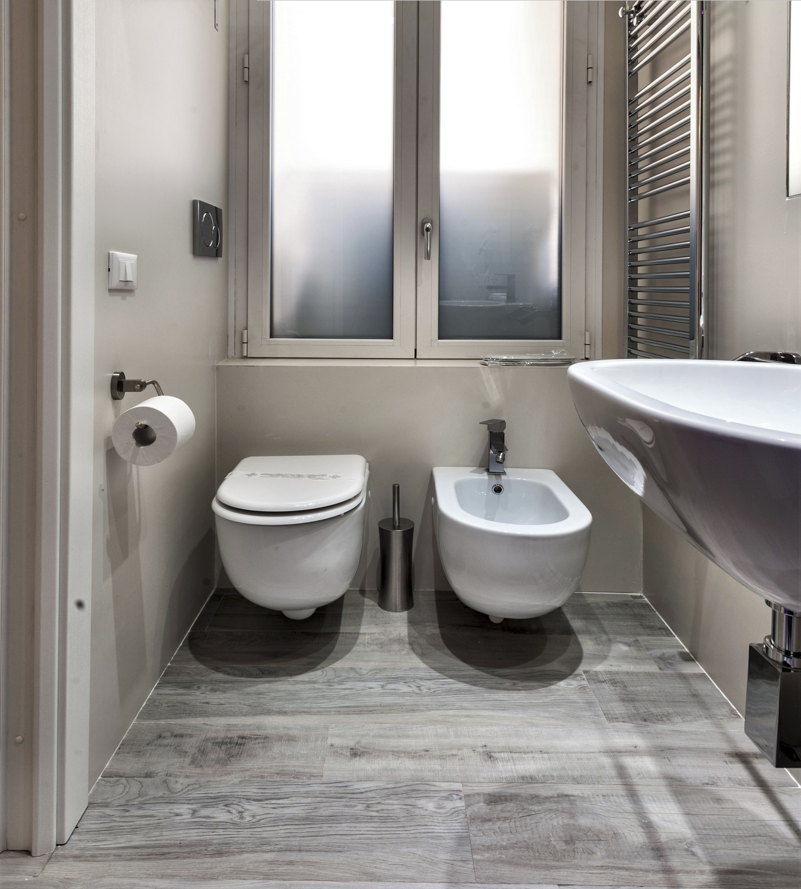 A modern bathroom with a toilet, bidet, and sink.