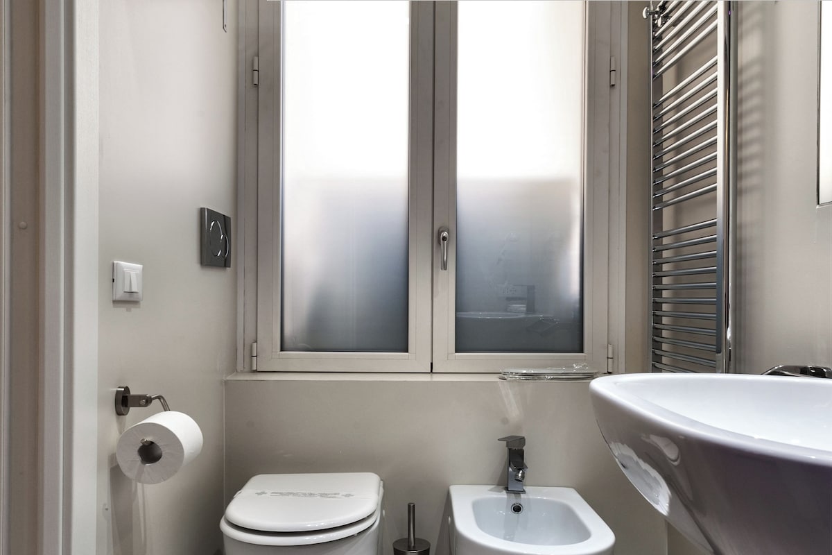 A modern bathroom with a toilet, bidet, and sink.