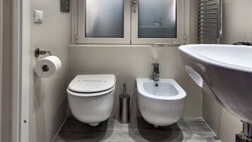 A modern bathroom with a toilet, bidet, and sink.
