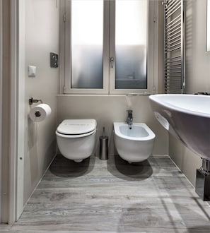 A modern bathroom with a toilet, bidet, and sink. - Foresteria Margherita Milano (Milan)