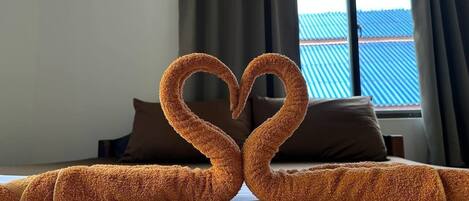 A bed with a heart-shaped arrangement of towels.