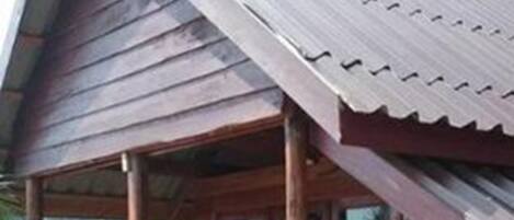 Una casa in legno con tetto in metallo, un balcone in legno e una finestra.