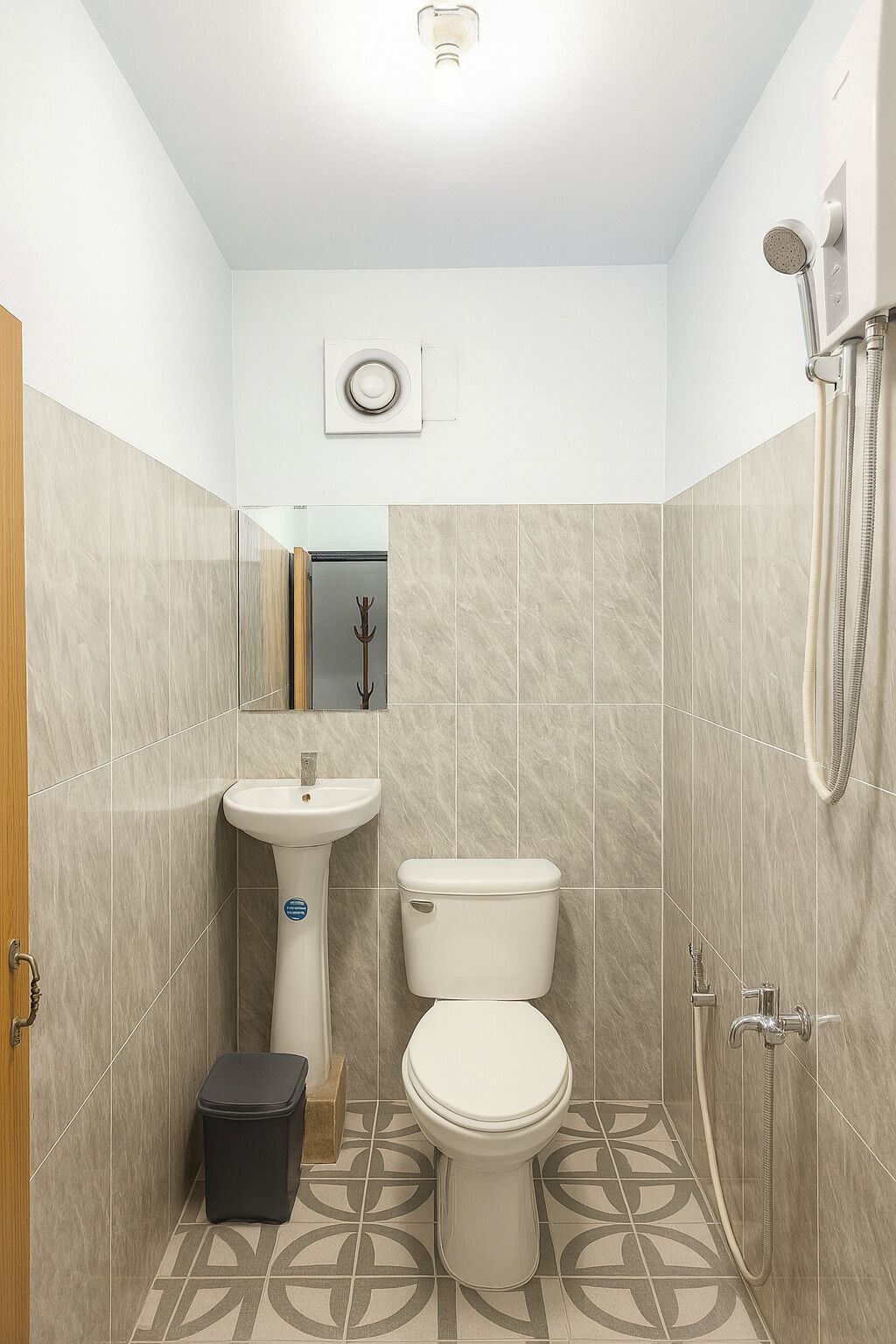 A compact bathroom with a toilet, sink, and shower.