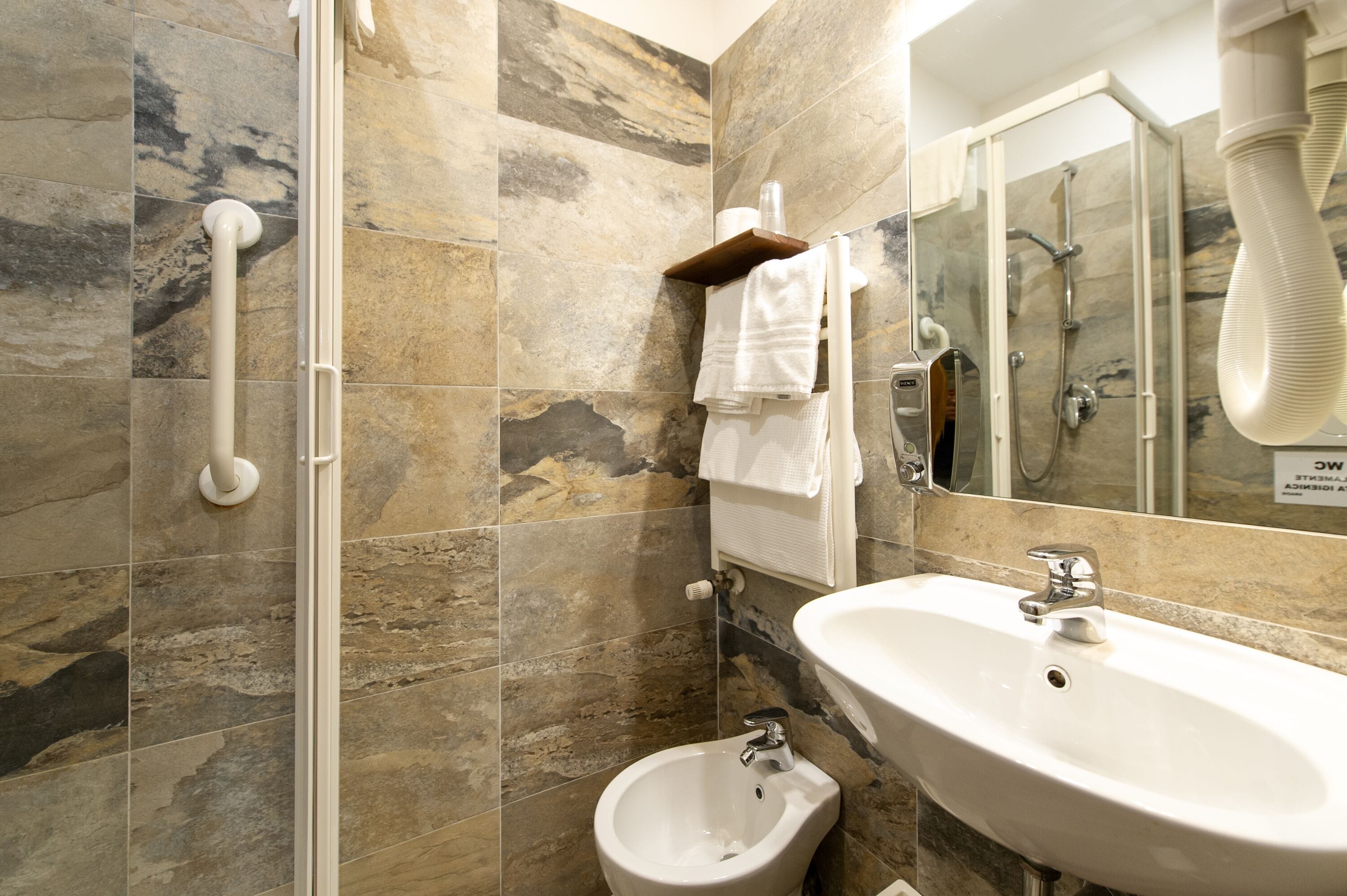 Un baño con bidé, lavamanos y ducha.