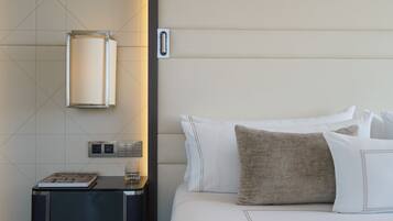 Habitación de hotel impecable con cama, mesita de noche y lámpara de pared.