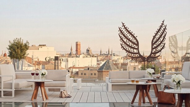 Terraza en la azotea con vistas a la ciudad, mobiliario y elementos decorativos.