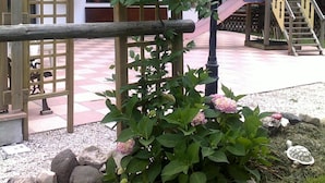A garden area with a wooden pergola, a lamp post, and a children's play structure. - Albergo Garni Defrancesco (Campitello di Fassa)