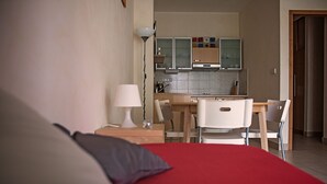 Una habitación de hotel con cama, escritorio y kitchenette.
