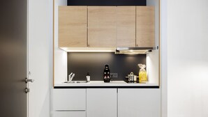 Een moderne keuken met witte kasten, een zwart aanrecht en een roestvrijstalen afzuigkap.
