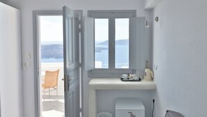 Ein Badezimmer mit Meerblick, einer Toilette, einem Waschbecken und einem Stuhl.