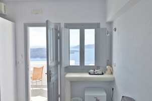 Un baño con vistas al mar, un inodoro, un lavamanos y una silla.