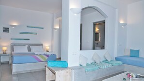 Ein modernes Hotelzimmer mit einem großen Bett, einem Sofa, einem Couchtisch und einem kleinen Tisch mit einer Vase.
