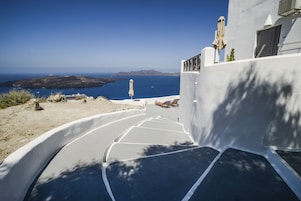 Un edificio blanco con un balcón curvo que da a la costa.