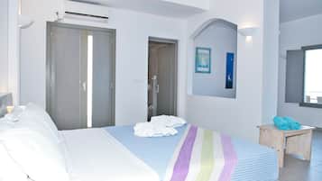 Un dormitorio con una cama, una mesita de noche de madera, una puerta de baño y un equipo de aire acondicionado instalado en la pared.