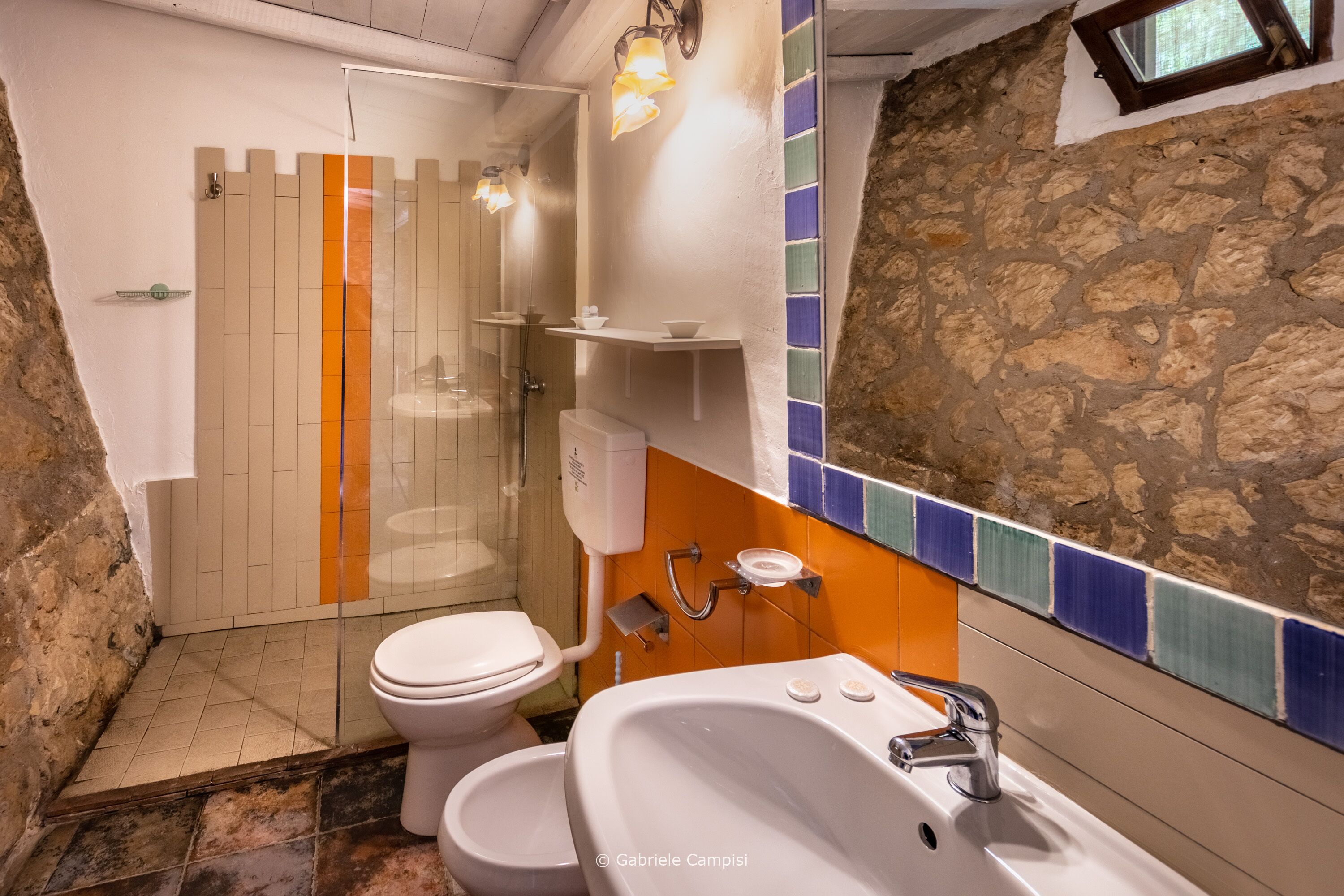 A bathroom with a white toilet, a white sink, and a shower area.
