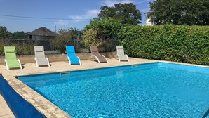 A rectangular swimming pool with clear blue water, surrounded by a tiled deck. - Logis Hôtel La Borie (Saint-Genies)