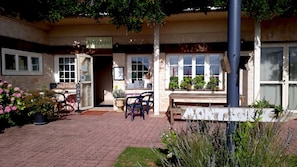 A restaurant with outdoor seating, a signboard, and potted plants. - Logis Hôtel La Borie (Saint-Genies)