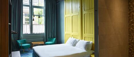 Ein Hotelzimmer mit Bett, Schreibtisch, Stuhl und einem fensterbepflegten Fenster.