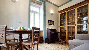 A dining area with a wooden table, chairs, and a cabinet with glass doors.