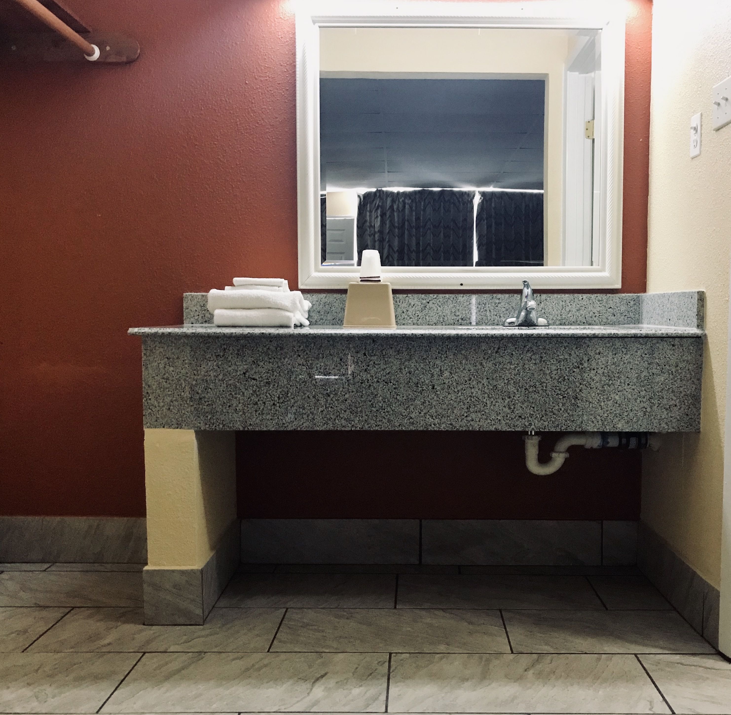Une salle de bain avec un lavabo en granit, un miroir et une fenêtre.