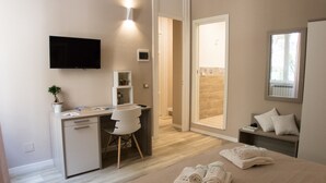 Quarto moderno com escrivaninha, cadeira e cama com toalhas.
