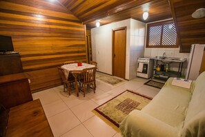 Un espacio habitable acogedor y funcional, con comedor, kitchenette y sofá.