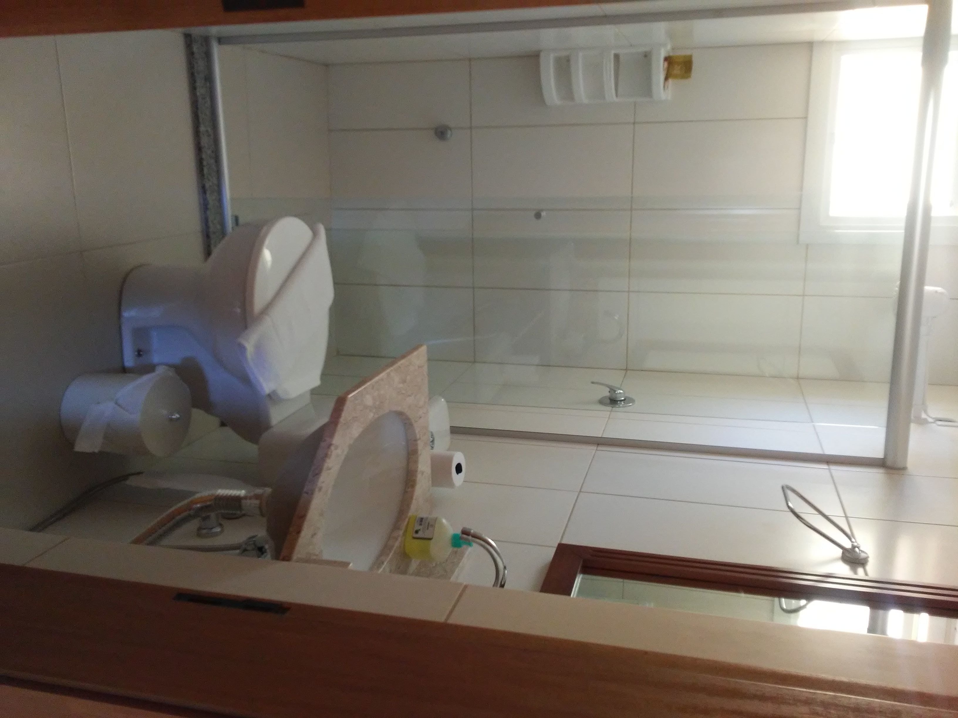 Baño con inodoro, zona de ducha y lavabo.