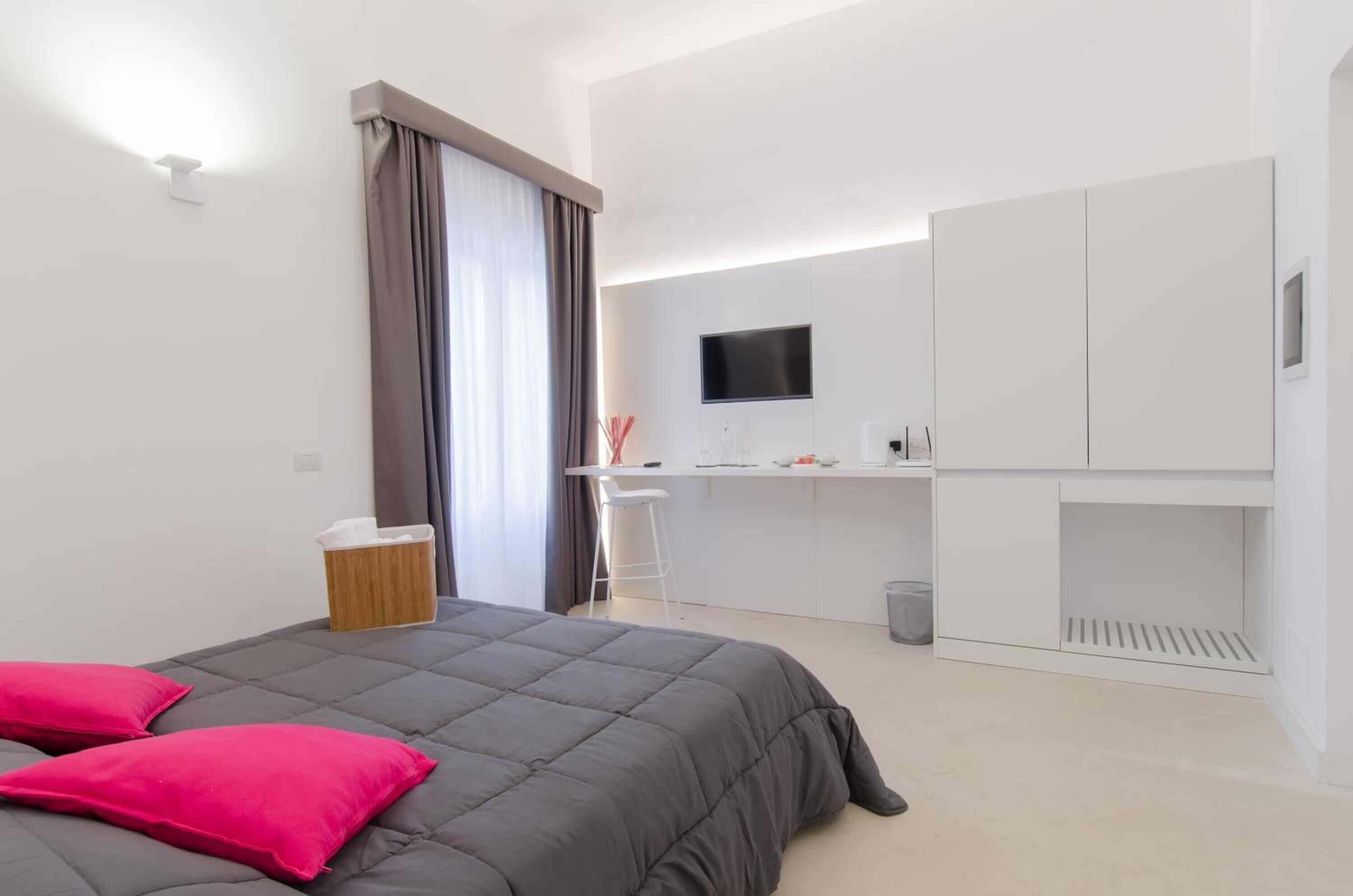 Una habitación de hotel moderna con cama, escritorio y televisión.