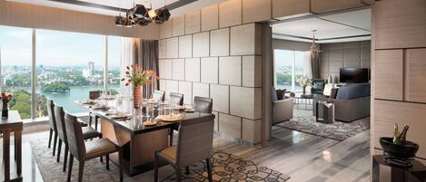 A modern dining area with a view of the city, a living room with a TV, and a large window.