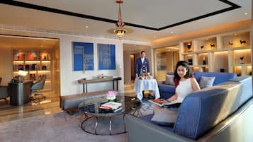 Un moderno hall de hotel con zona de estar, mostrador de recepción y exhibición de libros y objetos decorativos.
