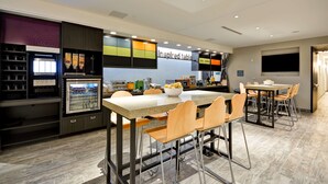 Une cuisine moderne dotée d’un îlot central, de tabourets de bar et d’une table à manger avec des chaises.