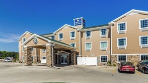 A hotel with a covered entrance, stone pillars, and a sign indicating it's a hotel and suites. - Cobblestone Hotel & Suites - Gering/Scottsbluff (Gering)