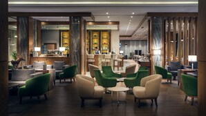 Eine großzügige Lobby mit Barbereich, Sitzgelegenheiten und einer Rezeption.