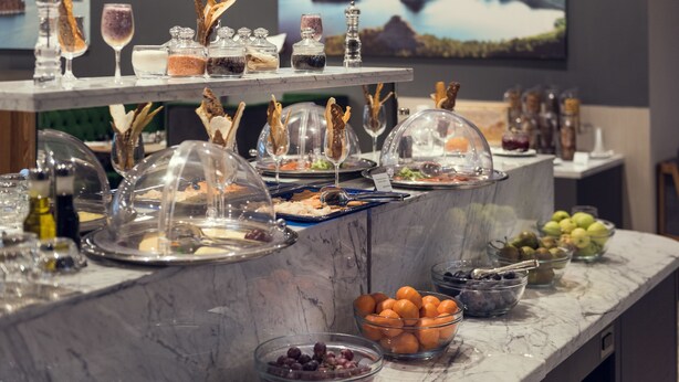 Ein reichhaltiges Buffet mit verschiedenen Speisen und Getränken auf einer Marmorplatte.